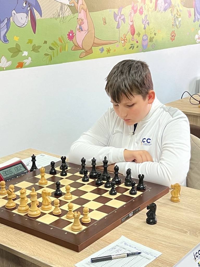 Sportiv ICC Iași în echipamentul clubului, la o tablă de șah electronică, într-un concurs